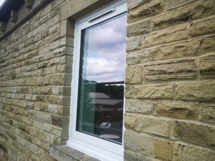 A replacement window installed in the stone facade